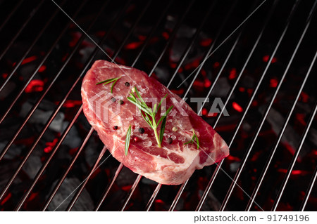 Raw steak on a grill. Raw steak on a grill. 91749196