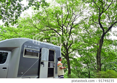 A man who enjoys camping easily with a camper A man who enjoys camping easily with a camper 91749235