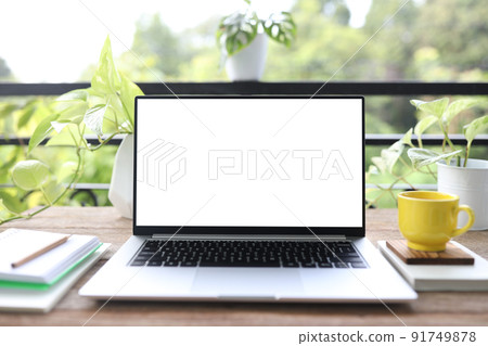Laptop and yellow coffee cup and plant pot on wooden table at balcony Laptop and yellow coffee cup and plant pot on wooden table at balcony 91749878