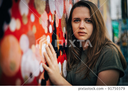 Beautiful female street fashion model poses for the camera in the colorful streets of Miami 91750379