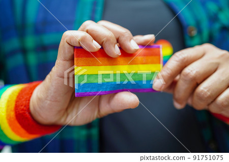 Asian woman with rainbow flag, LGBT symbol rights and gender equality, LGBT Pride Month in June. Asian woman with rainbow flag, LGBT symbol rights and gender equality, LGBT Pride Month in June. 91751075
