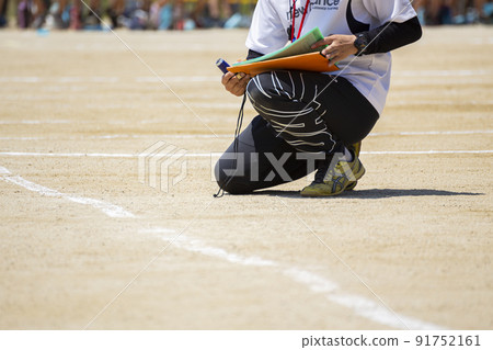 A teacher confirming the next schedule at the athletic meet 91752161