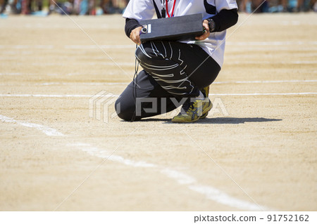 A teacher confirming the next schedule at the athletic meet 91752162