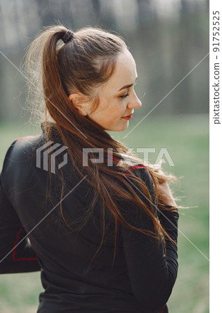 Woman in a black sportswear. Girl in a spring park. Woman in a black sportswear. Girl in a spring park. 91752525