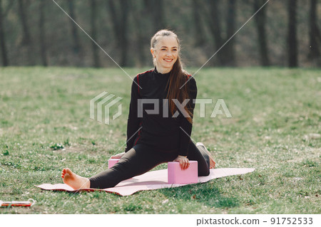 Beautiful girl training. Girl in a summer park. Lady make a yoga Beautiful girl training. Girl in a summer park. Lady make a yoga 91752533