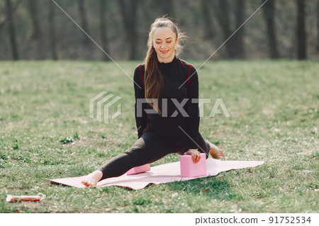 Beautiful girl training. Girl in a summer park. Lady make a yoga Beautiful girl training. Girl in a summer park. Lady make a yoga 91752534