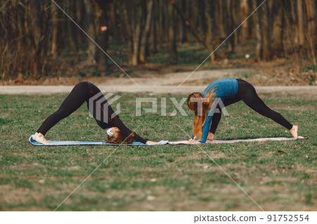 Beautiful girls training. Girls in a summer park. Lady make a yoga. Coronavirus theme 91752554