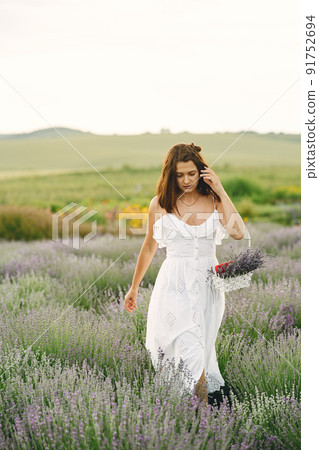 Provence woman relaxing in lavender field. Lady in a white dress. Girl with bag. 91752694