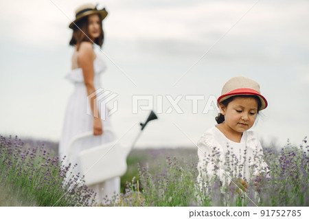 Mother with little daughter on lavender background. Beautiful woman and cute baby playing in meadow field. Family holiday in summer day. 91752785