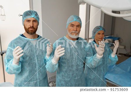 Team of surgeons in the operating room ready for surgery in clinic looking at camera 91753609