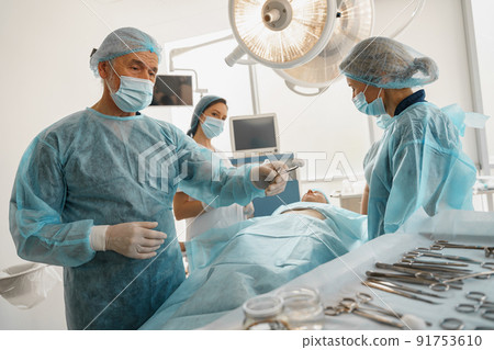 Concentrated surgical team working with a patient in an operation room 91753610