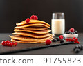 Mini pancakes with blueberries and raspberries. American breakfast on a dark background. Healthy eating for the whole family. Homemade pancakes with berries. 91755823