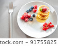 Food for breakfast healthy eating. Pancakes without butter with berries. Food for vegetarians and for dieting. American Pancakes Mini. Mini pancakes with blueberries and raspberries. American 91755825