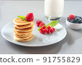 Pancakes with berries on a white plate. American Pancake Mini Pancakes with berries. 91755829