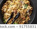 Italian fettuccini pasta close-up. Black pasta tongs with pasta. Pasta alfredo with mushrooms. Top view. Linguine with mushrooms, white cheese, spinach and garlic. Healthy eating. Vegetarian food 91755831