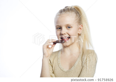 Beautiful girl eating chocolate. Beautiful girl eating chocolate. 91758926