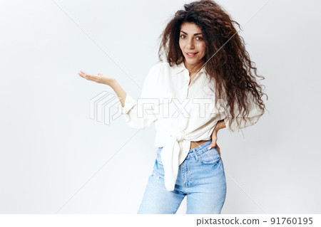 Cheerful Curly Pretty Latin Lady in White Shirt Holding Invisible Object Hand Up Showing copy space, free place Isolated At White Studio Wall Background. Good Offer, Banner Cheerful Curly Pretty Latin Lady in White Shirt Holding Invisible Object Hand Up Showing copy space, free place Isolated At White Studio Wall Background. Good Offer, Banner 91760195
