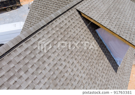 The roof of a house is being built with asphalt shingles in the construction 91763381