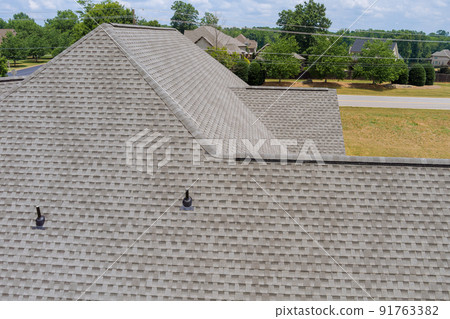 In building construction, a new roof is being installed on a house roof covering asphalt shingles. 91763382