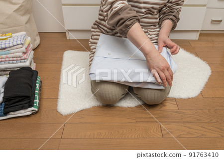 [Middle housewife's housework scene that folds laundry Y-shirt] 91763410