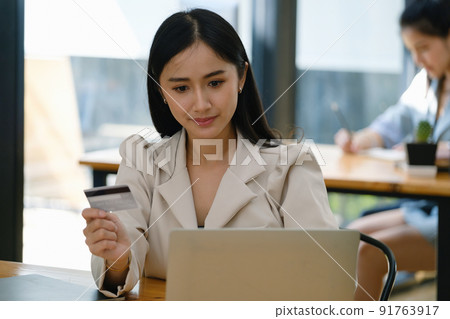 Online Shopping and Internet Payments, Beautiful Asian women are using their credit cards and computer laptop to shop online or conduct errands in the digital world. Online Shopping and Internet Payments, Beautiful Asian women are using their credit cards and computer laptop to shop online or conduct errands in the digital world. 91763917