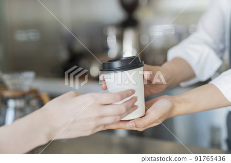Female staff handing over cafe products 91765436