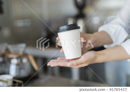 Female staff handing over cafe products 91765437