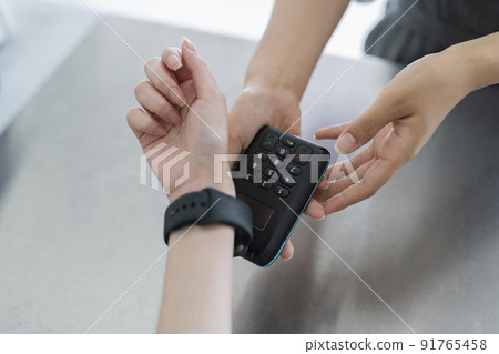A woman making a cashless payment at a cafe 91765458