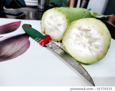 Sliced bottle gourd with Knife on the table Sliced bottle gourd with Knife on the table 91770525