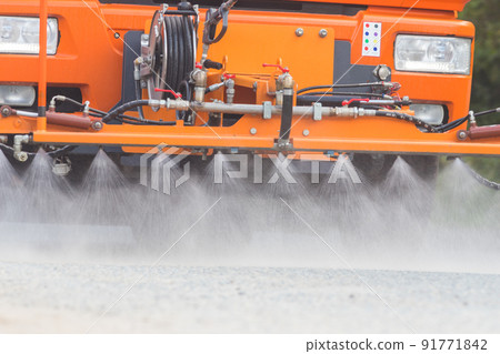 Big orange machine clears the asphalt with directed water streams Big orange machine clears the asphalt with directed water streams 91771842