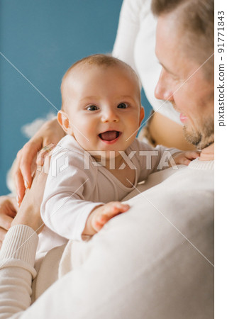 A smiling baby in the arms of his young happy dad A smiling baby in the arms of his young happy dad 91771843