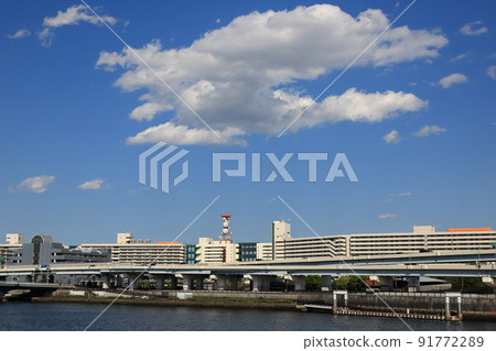 A huge housing complex along the Sumida River and clouds that spring up in the blue sky 91772289