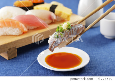 Horse mackerel nigiri sushi lifted with chopsticks Horse mackerel nigiri sushi lifted with chopsticks 91774349