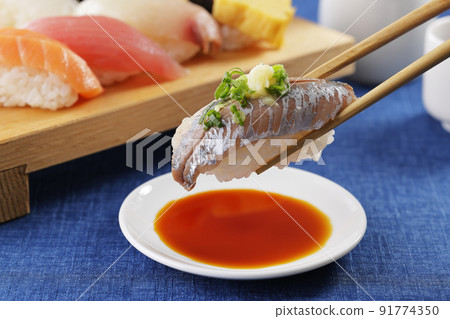 Horse mackerel nigiri sushi lifted with chopsticks Horse mackerel nigiri sushi lifted with chopsticks 91774350