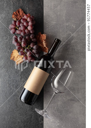 Red wine with grapes on a stone background. 91774457