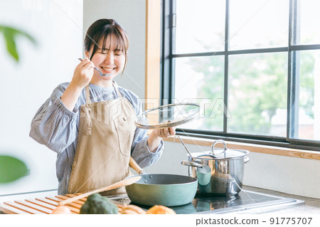 一個女人在廚房裡品嚐食物 91775707