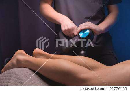 Rehabilitation. Massage therapist performs prophylactic percussive massage Rehabilitation. Massage therapist performs prophylactic percussive massage 91776433