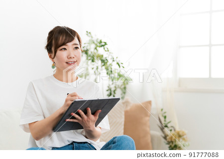 A woman who uses a tablet at home (manga artist, painter, novelist) 91777088