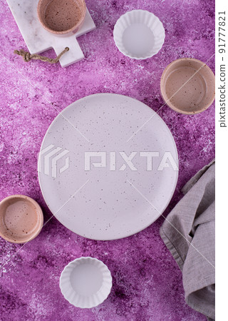 Plate, bowls and cutting board on lilac background Plate, bowls and cutting board on lilac background 91777821