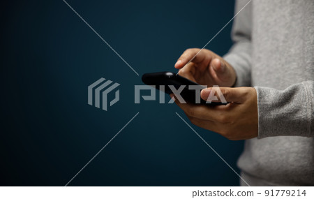 Closeup of Hand Using Mobile Phone. Cropped image. Selective Focus. Using Smartphone for Communication, Texting, Reading or Playing Game Closeup of Hand Using Mobile Phone. Cropped image. Selective Focus. Using Smartphone for Communication, Texting, Reading or Playing Game 91779214