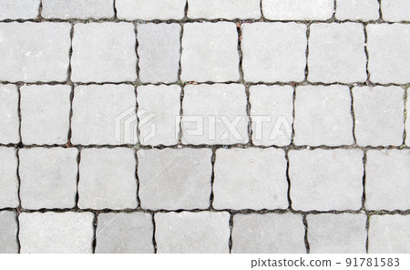 Concrete or paved newly laid gray paving slabs or stones for floors or walkways. Concrete paving slabs in the backyard or road paving. Garden brick path in the courtyard on a sandy foundation. 91781583