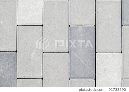 Concrete or paved newly laid gray paving slabs or stones for floors or walkways. Concrete paving slabs in the backyard or road paving. Garden brick path in the courtyard on a sandy foundation. Concrete or paved newly laid gray paving slabs or stones for floors or walkways. Concrete paving slabs in the backyard or road paving. Garden brick path in the courtyard on a sandy foundation. 91782290