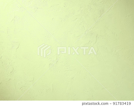 Horizontal background image where light yellow-green light hits the plastered wall with trowel marks 91783419