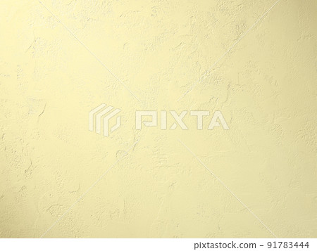 A horizontally long background image in which a light yellow light hits a plastered wall with trowel marks. 91783444