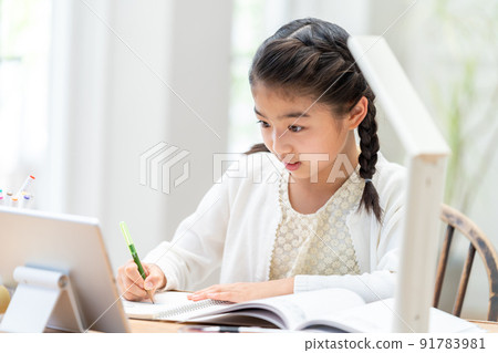 Elementary school girl studying while looking at a tablet 91783981