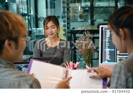 Software developers team brainstorming and discussing project together in startup office Software developers team brainstorming and discussing project together in startup office 91784450