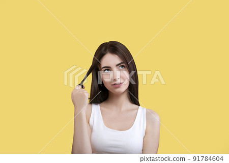 Portrait of a cute girl in a white top on a yellow background Portrait of a cute girl in a white top on a yellow background 91784604