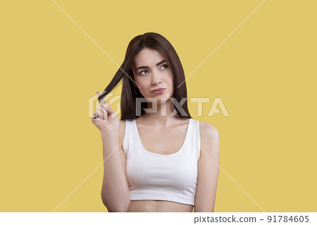 Portrait of a cute girl in a white top on a yellow background Portrait of a cute girl in a white top on a yellow background 91784605
