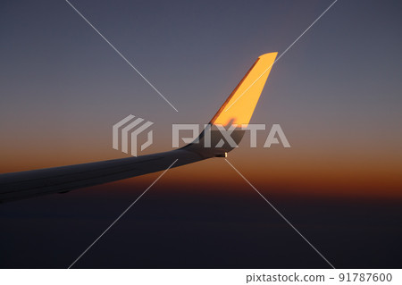 Plain wing against beautiful sunset. Flight from Amsterdam to Helsinki. Plain wing against beautiful sunset. Flight from Amsterdam to Helsinki. 91787600