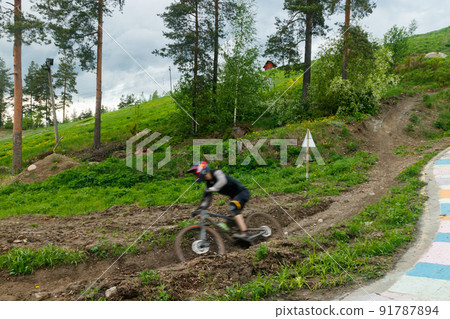 Mountain biker is riding down the hill Mountain biker is riding down the hill 91787894